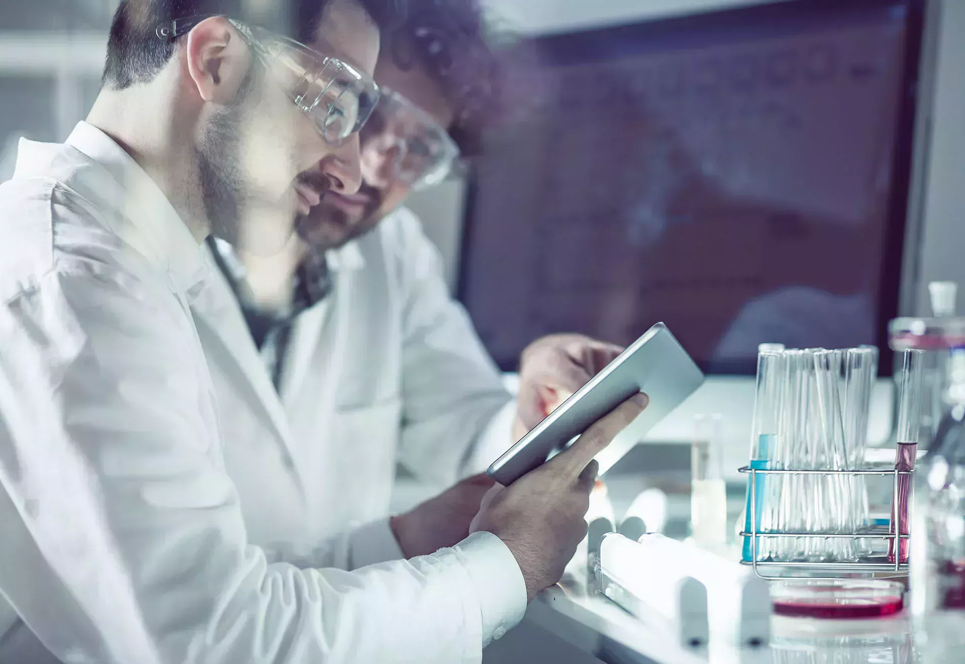 Dos técnicos químicos están en el laboratorio mirando una tableta